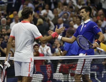 Novak Djokovic of Serbia (R) shakes hands with Roger Federer of Switzerland after Djokovic won their men's singles final match at the U.S. Open Championships tennis tournament in New York, September 13, 2015. REUTERS/Mike Segar