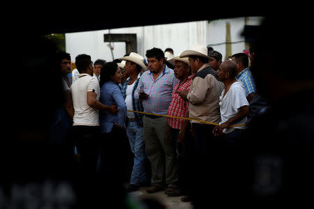 Supporters of slain mayoral candidate Santana Cruz Bahena stand at a crime scene outside his home in the municipality of Hidalgotitlan, in the state of Veracruz, Mexico November 20, 2017. REUTERS/Angel Hernandez