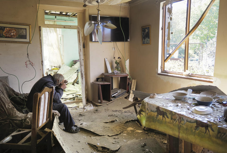 Yury Melkonyan, 64, sits in his house damaged by shelling from Azerbaijan's artillery during a military conflict in Shosh village outside Stepanakert, the separatist region of Nagorno-Karabakh, Saturday, Oct. 17, 2020. The latest outburst of fighting between Azerbaijani and Armenian forces began Sept. 27 and marked the biggest escalation of the decades-old conflict over Nagorno-Karabakh. The region lies in Azerbaijan but has been under control of ethnic Armenian forces backed by Armenia since the end of a separatist war in 1994. (AP Photo)