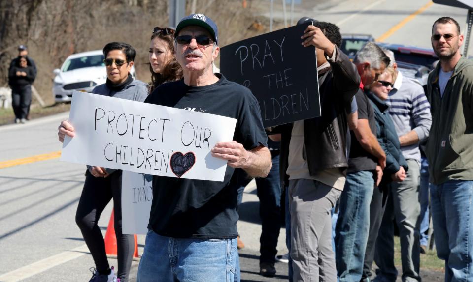 People hold signs as they oppose the Drag Queen Story Hour held at the MBE Children's Chapter on Factory Street in Montgomery, New York, April 1, 2023. Supporters and those opposed gathered on Route 17K across the street from the bookstore. 