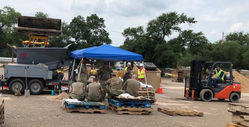 Corps of Engineers and National Guard fill bags of sand at the Happy State Bank Stadium in Canyon for those needing a barrier from the flooding in Canyon and Amarillo.