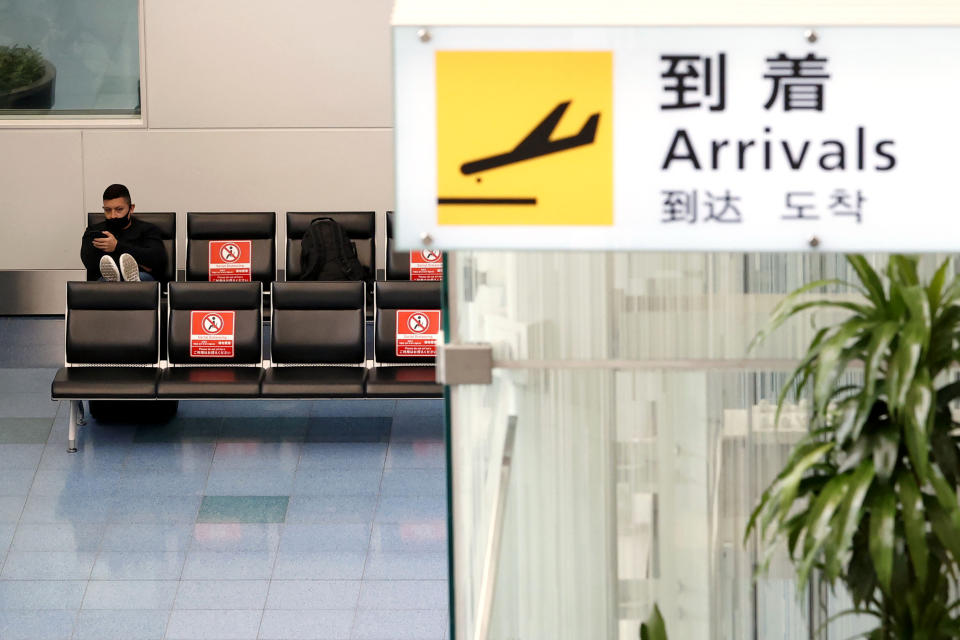 A passenger sits at the international terminal of Haneda Airport in Tokyo, Japan, Tuesday, Nov. 30, 2021. Japan confirmed on Tuesday its first case of the new omicron coronavirus variant, a visitor who recently arrived from Namibia, an official said. Japan announced Monday it will suspend entry of all foreign visitors from around the world as a new coronavirus variant spreads (Shinji Kita/Kyodo News via AP)