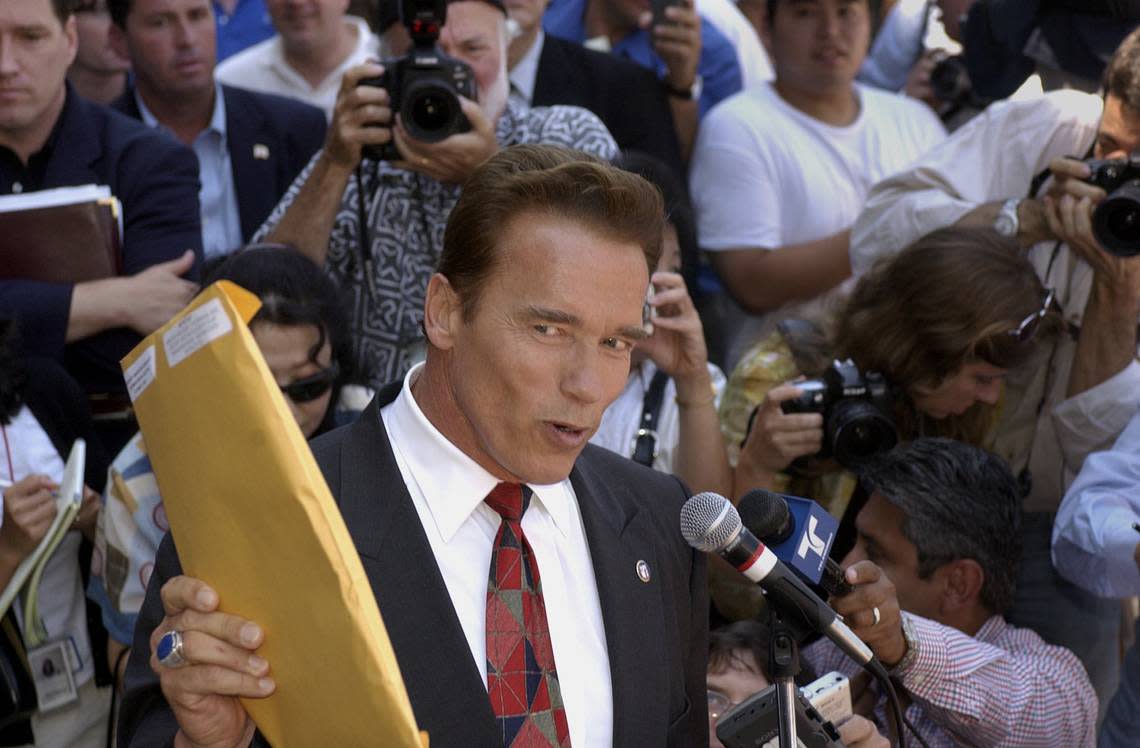 Arnold Schwarzenegger holds up the papers he picked up at the Los Angeles County Registrars Office in Norwalk on Aug. 7, 2003, saying that his is going to clean house in Sacramento. John Decker/Sacramento Bee file