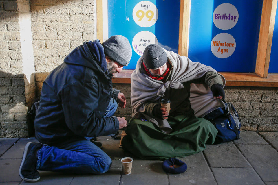 Two beggars in Ely with hot drinks given to them by the public (Picture: SWNS)