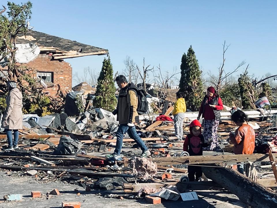 People amongst damage caused by tornados in Mayfield, Kentucky, USA, 12 December 2021 (EPA)