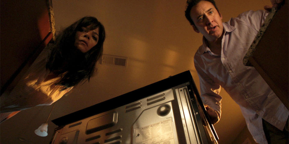 Selma Blair and Nicolas Cage looking down.