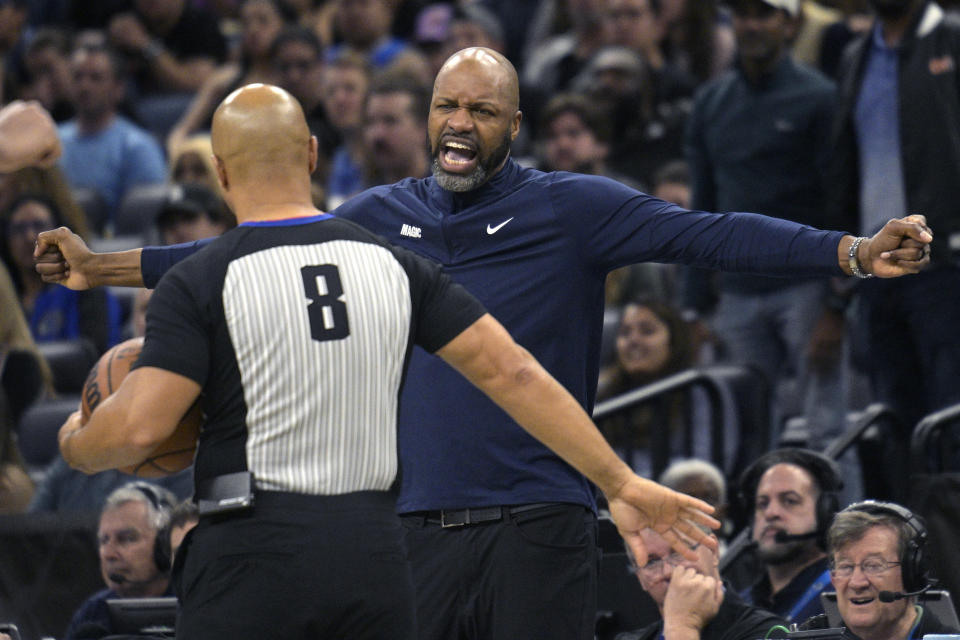 Orlando Magic head coach Jamahl Mosley, right, argues a call with official Marc Davis (8) during the second half of an NBA basketball game against the Phoenix Suns, Sunday, Jan. 28, 2024, in Orlando, Fla. (AP Photo/Phelan M. Ebenhack)