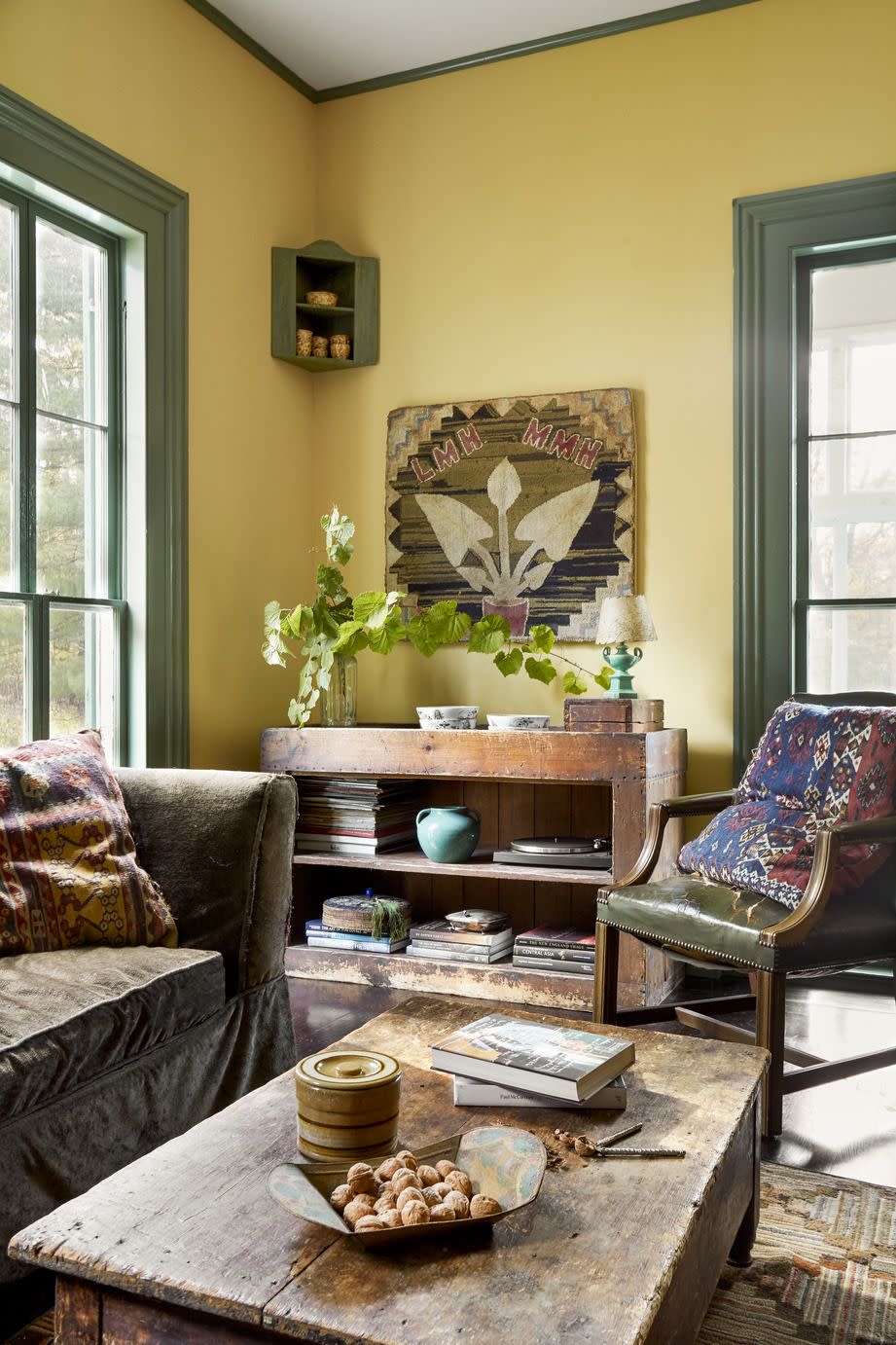 living room with soft yellow walls and green painted trim, vintage furniture