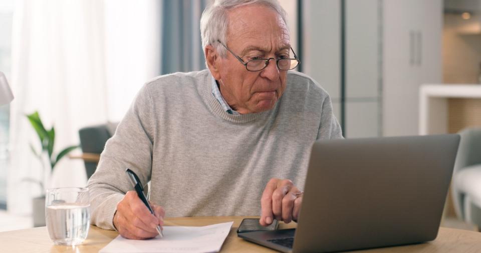 A person with a serious expression on a laptop.