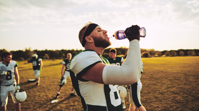 football player drinking sports drink