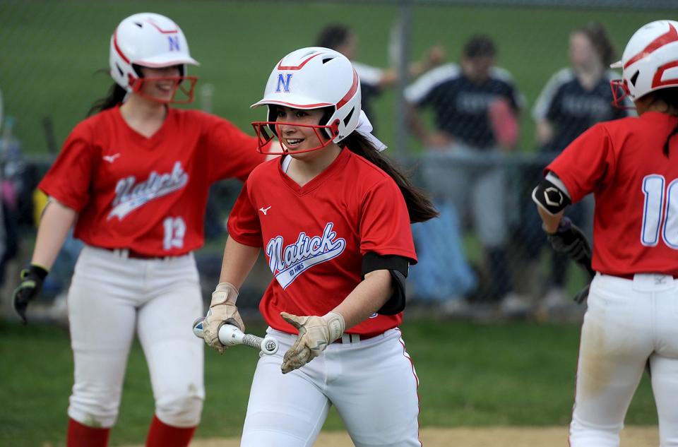 Natick High School softball player Olivia Schultz smiles after crossing the plate at Framingham, April 13, 2022.