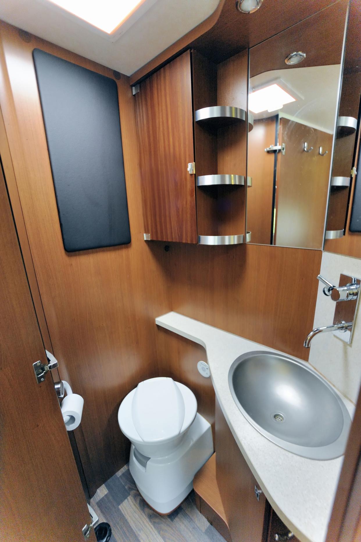 Inside of RV with washroom toilet sink shower cabinet