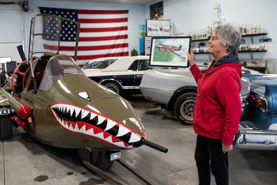 Pat VanderPol holds up a drawing of the "Freedom Fighter" next to the vehicle. Gary VanderPol built it using the canopy of an airplane he got in New Mexico.