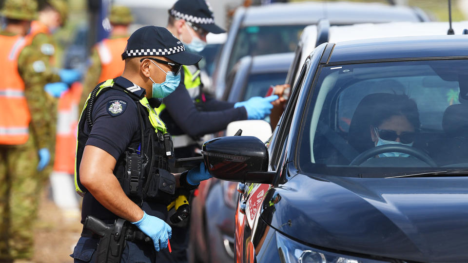 Police and ADF personnel, pictured here at a roadside checkpoint near the Victorian border.