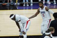 Los Angeles Clippers guard Paul George (13) and Clippers guard Reggie Jackson, left, pause on the court during the second half of Game 1 of the NBA basketball Western Conference finals against the Phoenix Suns, Sunday, June 20, 2021, in Phoenix. (AP Photo/Ross D. Franklin)