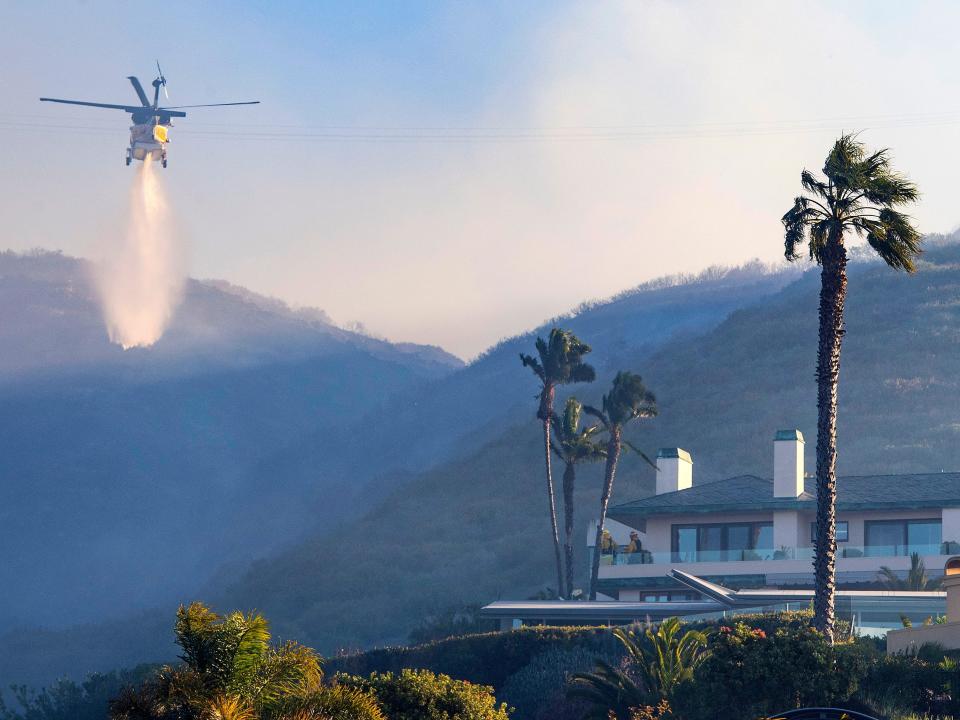 A helicopter makes a water drop.