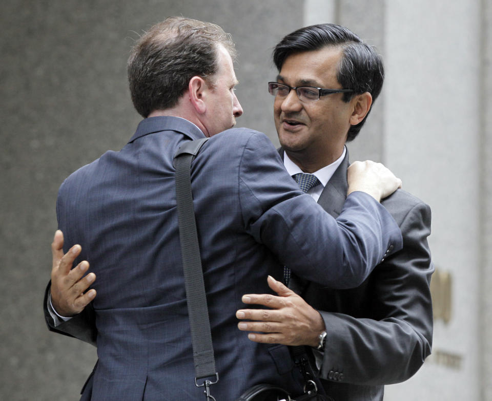 Anil Kumar, right, a former financial consultant-turned-government witness, hugs an unidentified man as he leaves Federal Court in New York, Thursday, July 19, 2012. Kumar was sentenced Thursday to two years of probation after prosecutors credited him with helping convict a pair of Wall Street titans on insider trading charges. (AP Photo/Richard Drew)