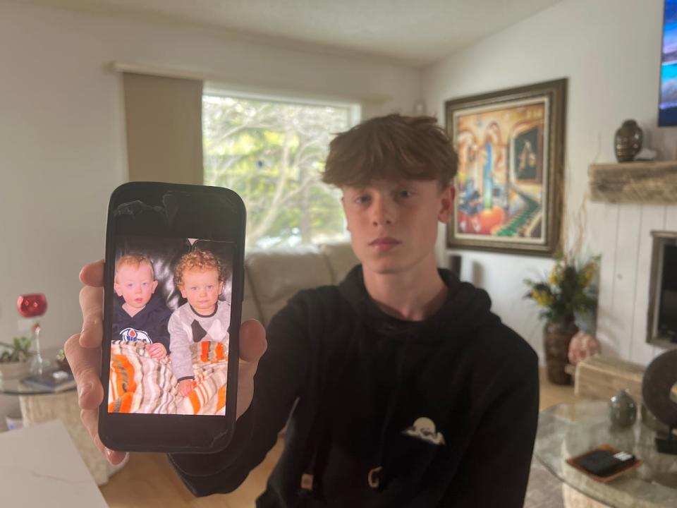 Seth Mathisen, right, holds up an old photo of him and Broden Radomske as toddlers.