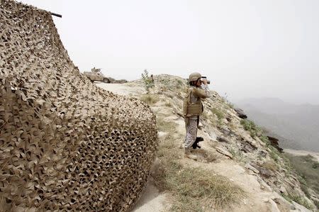 A Saudi soldier looks through binoculars at Saudi Arabia's border with Yemen April 6, 2015. REUTERS/Faisal Al Nasser