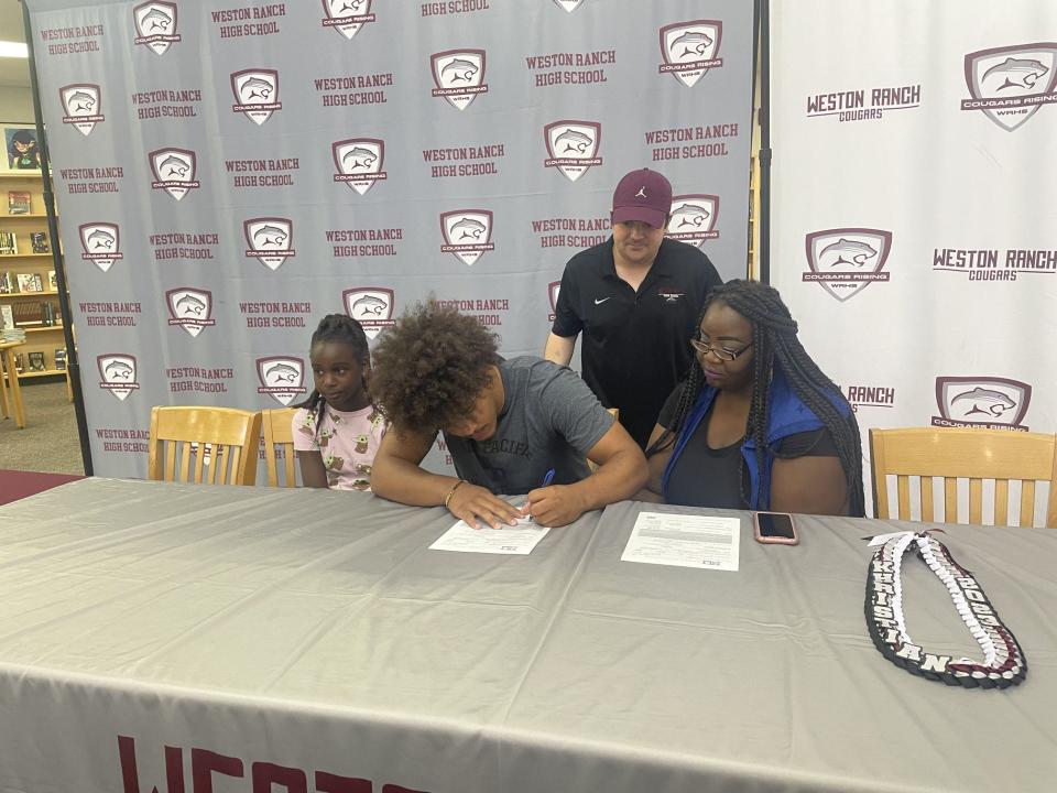 Khristian Holmes of Weston Ranch basketball signs his letter of intent to play basketball at Azusa Pacific University.