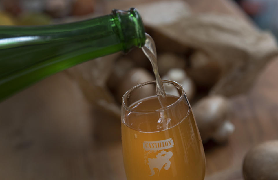 A Cantillon Lambic Gueuze is poured into a glass in Antwerp, Belgium, Saturday, Feb. 15, 2020. The Cantillon Brewery, where Lambic, Gueuze and Kriek have been made since 1900, produces organic beer six months a year. The Le Champignon de Bruxelles makes use of the waste from brewing the beer to make a substrate to grow mushrooms. (AP Photo/Virginia Mayo)