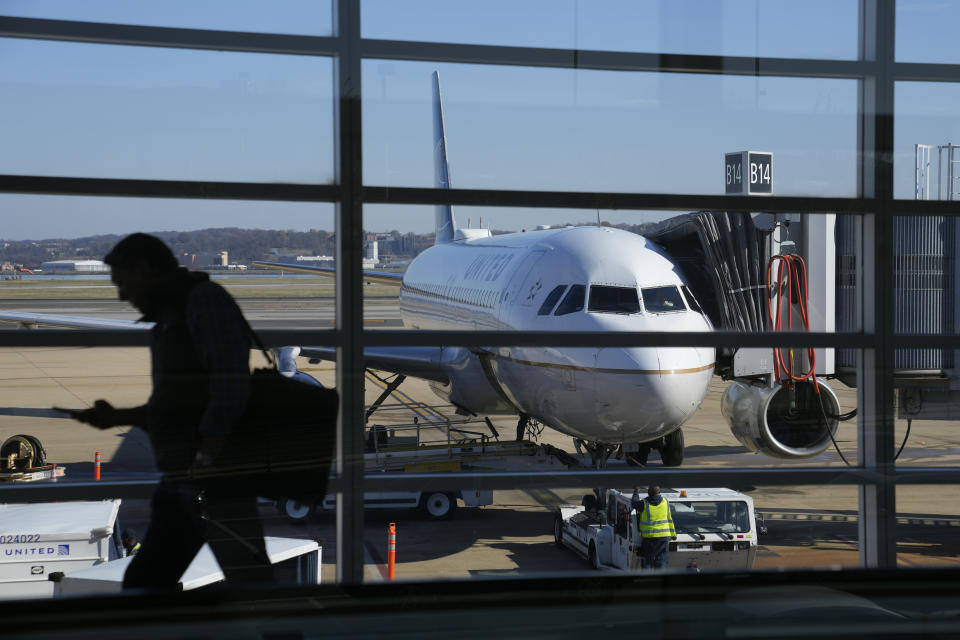 A United Airlines plane sits at a gate at Ronald Reagan Washington National Airport in Arlington, Va., Wednesday, Nov. 23, 2022. (AP Photo/Patrick Semansky)