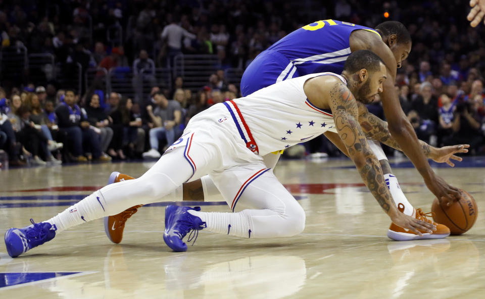 Philadelphia 76ers' Mike Scott, front, and Golden State Warriors' Kevin Durant dive for the ball during the first half of an NBA basketball game, Saturday, March 2, 2019, in Philadelphia. (AP Photo/Matt Slocum)