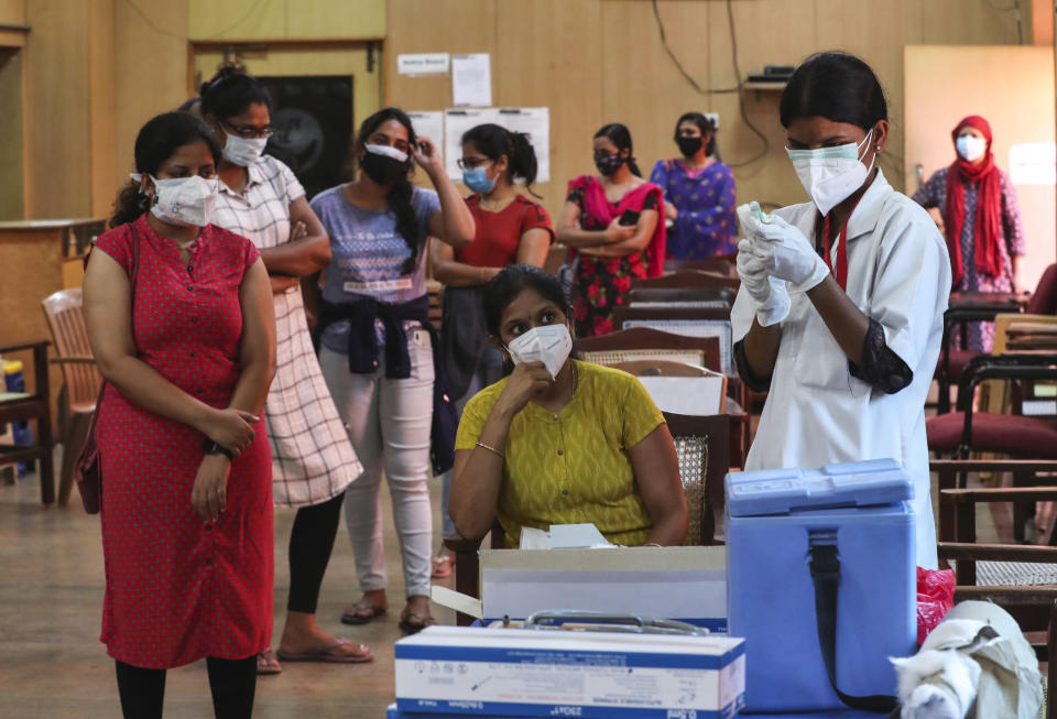 An Indian nurse prepares to administer a dose of Covishield, Serum Institute of India’s version of the AstraZeneca vaccine to a woman as others wait their turn in Bengaluru, India, Wednesday, May 19, 2021. India has the second-highest coronavirus caseload after the U.S. with more than 25 million confirmed infections. (AP Photo/Aijaz Rahi)