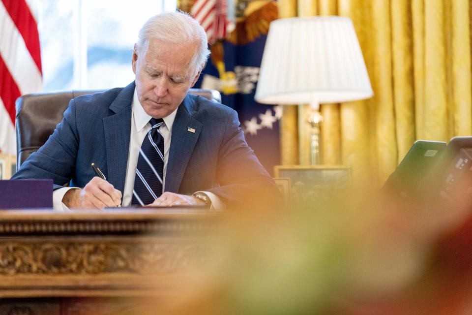 El presidente Joe Biden firma un paquete de rescate por 1,9 billones de dólares el 11 de marzo de 2021 para aliviar los estragos económicos causados por el coronavirus, en la Casa Blanca, en Washington. (AP Foto/Andrew Harnik)