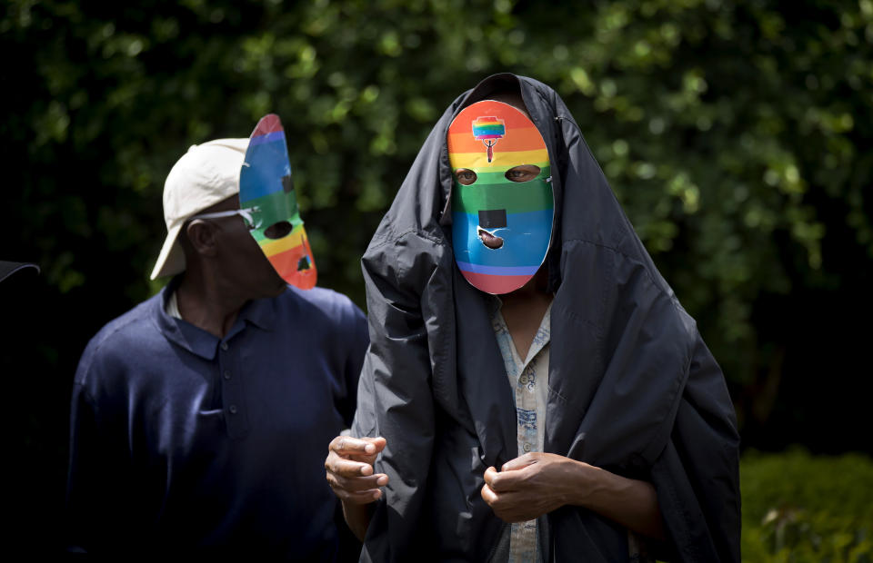 FILE - In this Feb. 10, 2014 file photo, Kenyan gays and lesbians and others supporting their cause wear masks to preserve their anonymity as they stage a rare protest, against Uganda's increasingly tough stance against homosexuality and in solidarity with their counterparts there, outside the Uganda High Commission in Nairobi, Kenya Monday, Feb. 10, 2014. Uganda's president Yoweri Museveni is expected to sign Monday, Feb. 24, 2014 a controversial anti-gay bill that allows harsh penalties for homosexual offenses, a bill which rights groups have condemned as draconian in a country where homosexuality is already illegal. (AP Photo/Ben Curtis, File)