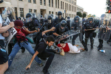 Protesters fall as they are pushed back by police in riot gear during a protest after a not guilty verdict in the murder trial of former St. Louis police officer Jason Stockley, charged with the 2011 shooting of Anthony Lamar Smith, who was black, in St. Louis, Missouri, U.S., September 15, 2017. Photo taken September 15, 2017. REUTERS/Lawrence Bryant