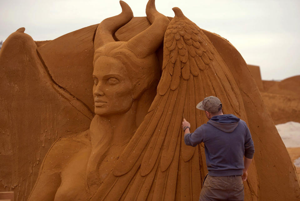 <p>A sand carver works on a sculpture during the Sand Sculpture Festival “Disney Sand Magic” in Ostend, Belgium. (Photo courtesy of Disneyland Paris) </p>