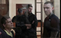 Russian soccer players Pavel Mamayev (R), Alexander Kokorin (L) and their acquaintance Alexander Protasovitsky, who are charged with a brutal assault and held in custody, are seen inside a defendants' cage as they attend a court hearing in Moscow, Russia May 6, 2019. REUTERS/Evgenia Novozhenina