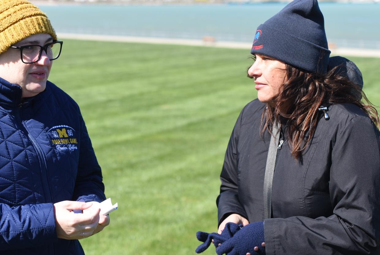 Laura Hillman, left, of Blue Water Allies meets with Mara McCalmon, founder of P.S. You're My Hero to receive a donation after the flower toss.