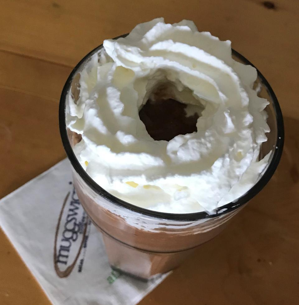 The Total Eclipse drink, available at Muggswigz Coffee & Tea, is a coffee-blended drink with chocolate and lavender that is rimmed with whipped cream.