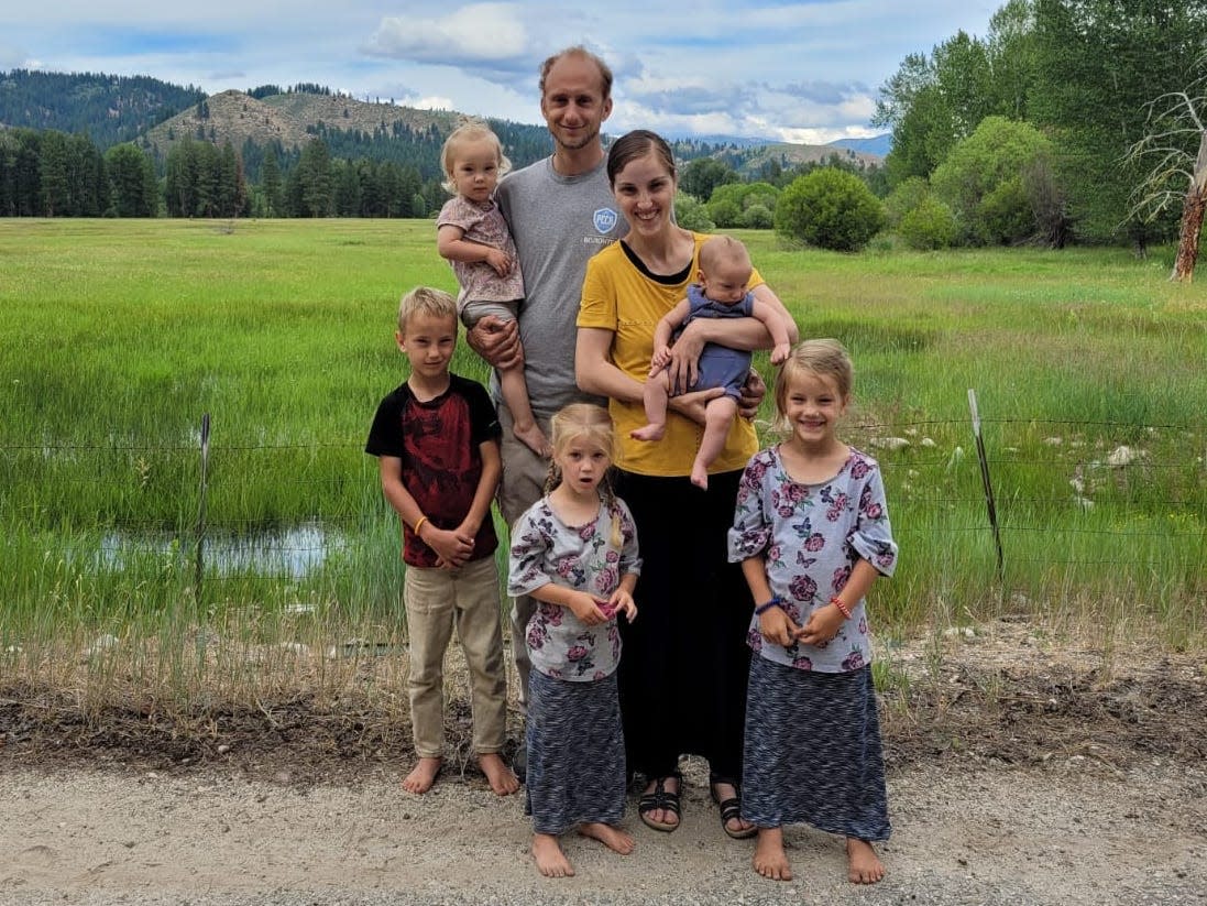 Daniel Beiler with his wife and five children standing in a rural landscape in Idaho