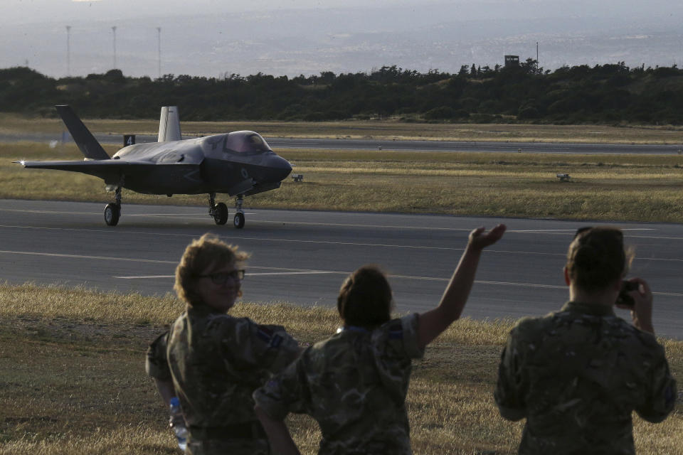 FILE - In this Tuesday, May 21, 2019 file photo, Soldiers wave at a F-35B aircraft waves after landing at Akrotiri Royal air forces base near coastal city of Limassol, Cyprus. Britain's defense secretary said the country's most advanced military aircraft, the Lightning F-35B, that is undergoing training at a British air base in Cyprus has flown its first missions over Syria and Iraq as part of the ongoing operations against the Islamic State group, in a statement issued Tuesday June 25, 2019. (AP Photo/Petros Karadjias, File)