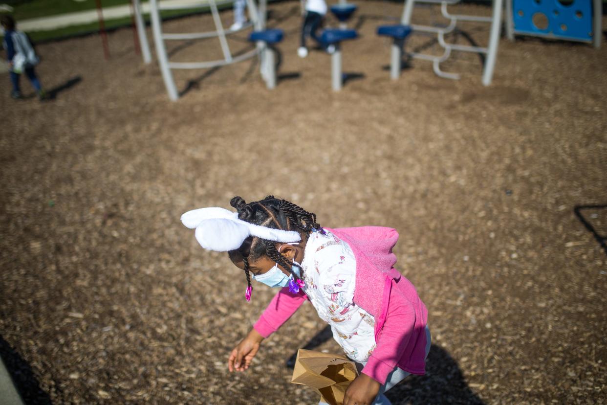 Avanni Stevenson, 5, hunts for Easter eggs hidden in the playground at The Grove At Keith Creek Saturday, April 3, 2021, in Rockford.