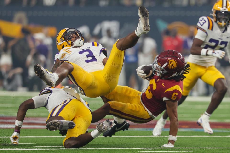 USC wide receiver Makai Lemon, right, is tackled by LSU safety Sage Ryan (3) in the first half Sunday.