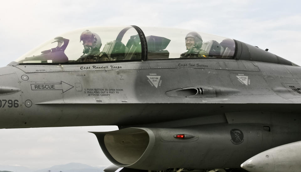 CAPTION CORRECTION, CORRECTS BYLINE - Romanian prime minister Victor Ponta, right, smiles from the cockpit of a US Air Force F-16 fighter jet piloted by Maj. Dustin Yogi Brown during a military exercise in Campia Turzii, Romania, Thursday, April 17, 2014. Dressed in a flight suit, Ponta visited the Campia Turzii military air base in northwest Romania where about 450 U.S. and Romanian troops and technical staff had been taking part in the weeklong exercises ending Thursday. (AP Photo/Mihaela Bobar)