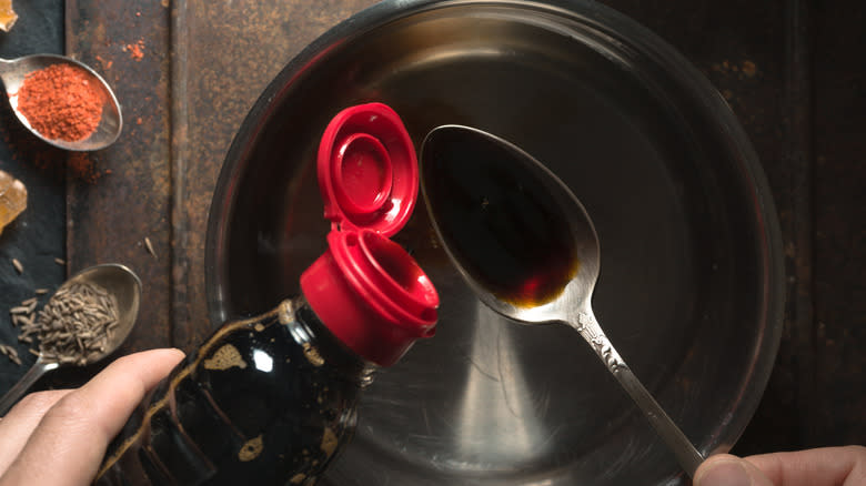 Pouring soy sauce into a pan