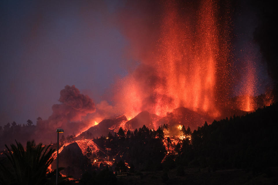 EL PASO, SPAIN - SEPTEMBER 19: Mount Cumbre Vieja erupts in El Paso, spewing out columns of smoke, ash and lava as seen from Los Llanos de Aridane on the Canary island of La Palma on September 19, 2021. - The Cumbre Vieja volcano erupted on Spain's Canary Islands today spewing out lava, ash and a huge column of smoke after days of increased seismic activity, sparking evacuations of people living nearby, authorities said. Cumbre Vieja straddles a ridge in the south of La Palma island and has erupted twice in the 20th century, first in 1949 then again in 1971. (Photo by Andres Gutierrez/Anadolu Agency via Getty Images)