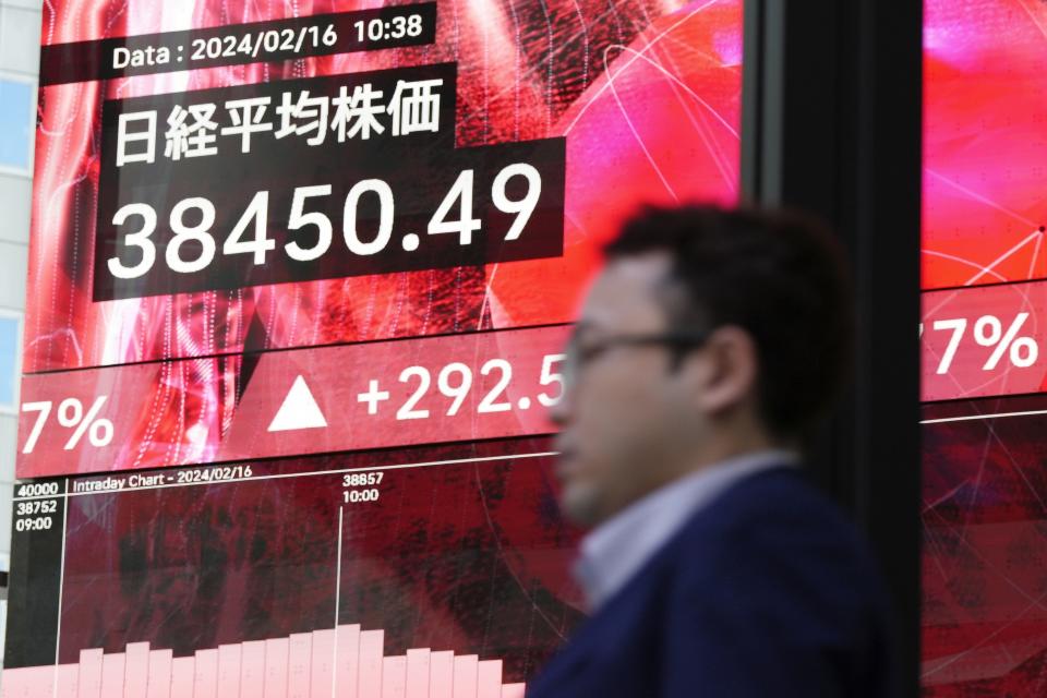 A person walks in front of an electronic stock board showing Japan's Nikkei 225 index at a securities firm Friday, Feb. 16, 2024, in Tokyo. Shares advanced in Asia on Friday, with Tokyo's benchmark Nikkei 225 index trading near a record high, 34 years after it peaked and then plunged with the collapse of Japan's financial bubble. (AP Photo/Eugene Hoshiko)