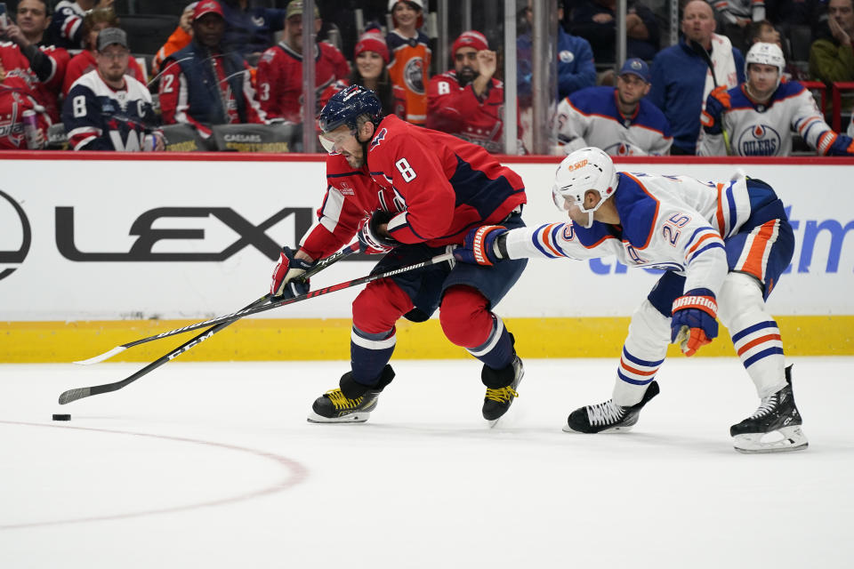 Washington Capitals left wing Alex Ovechkin, left, skates with the puck past Edmonton Oilers defenseman Darnell Nurse in the third period of an NHL hockey game, Monday, Nov. 7, 2022, in Washington. (AP Photo/Patrick Semansky)