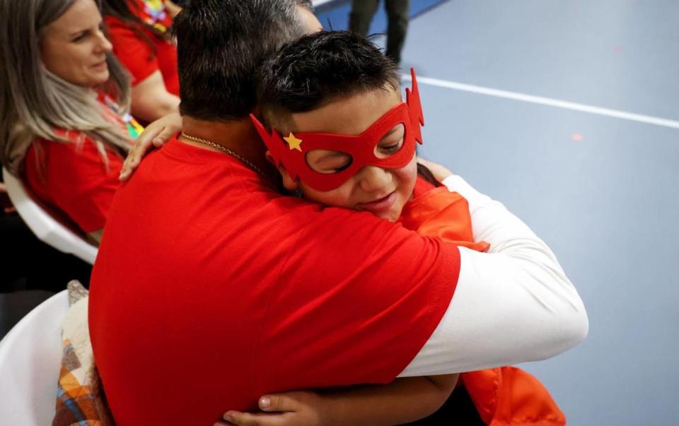 Ramon Rodriguez Jr., a second-grader at Cesar Chavez Elementary, hugs his godfather, Carlos Rodriguez, after being named an American Heart Association Youth Heart Ambassador during a school assembly on Friday, January 12, 2024. As a Youth Heart Ambassador, Rodriguez, who was born with his heart upside down, will share his story of living with heart disease.
