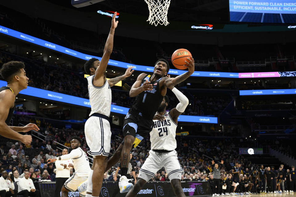 Marquette guard Kam Jones (1) goes to the basket between Georgetown forward Supreme Cook (24) and guard Dontrez Styles, third from right, during the first half of an NCAA college basketball game, Saturday, Feb. 3, 2024, in Washington. (AP Photo/Nick Wass)
