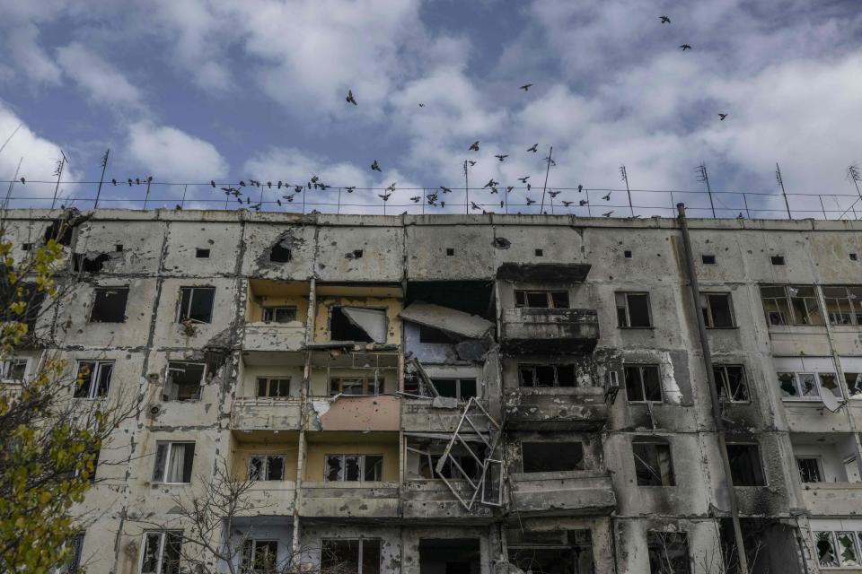Birds fly over a damaged building in the Kherson region village of Arkhanhelske on November 3, 2022, which was formerly occupied by Russian forces.
