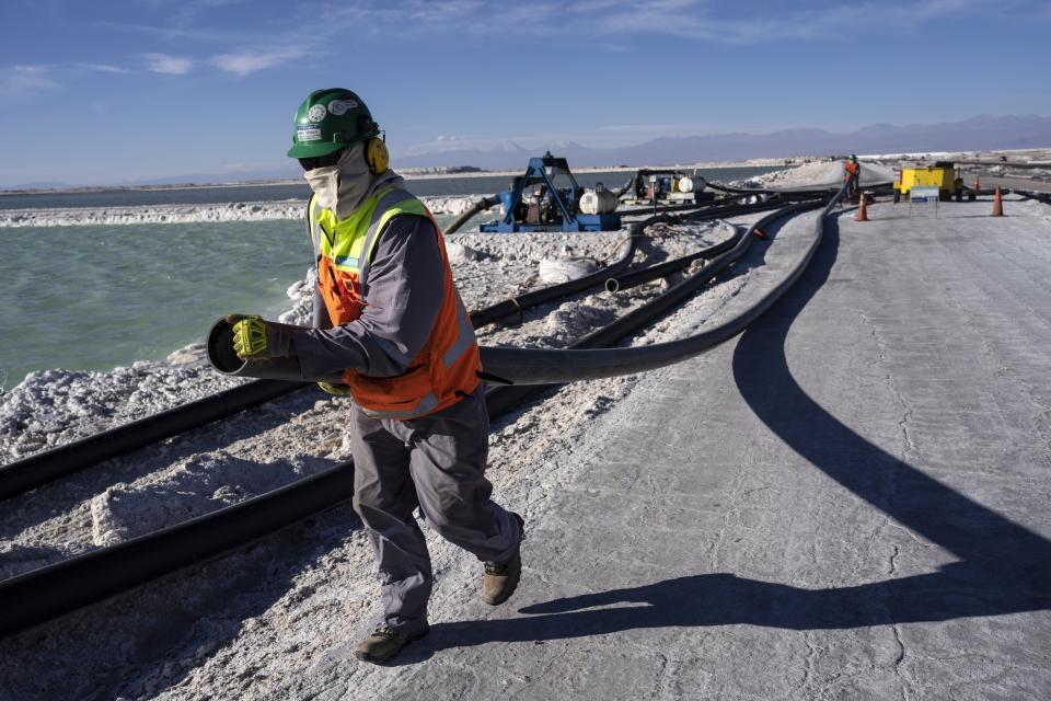 Workers perform maintenance next to pools of brine slowly turning into lithium at the Albemarle lithium mine in Chile's Atacama desert, Monday, April 17, 2023. (AP Photo/Rodrigo Abd)