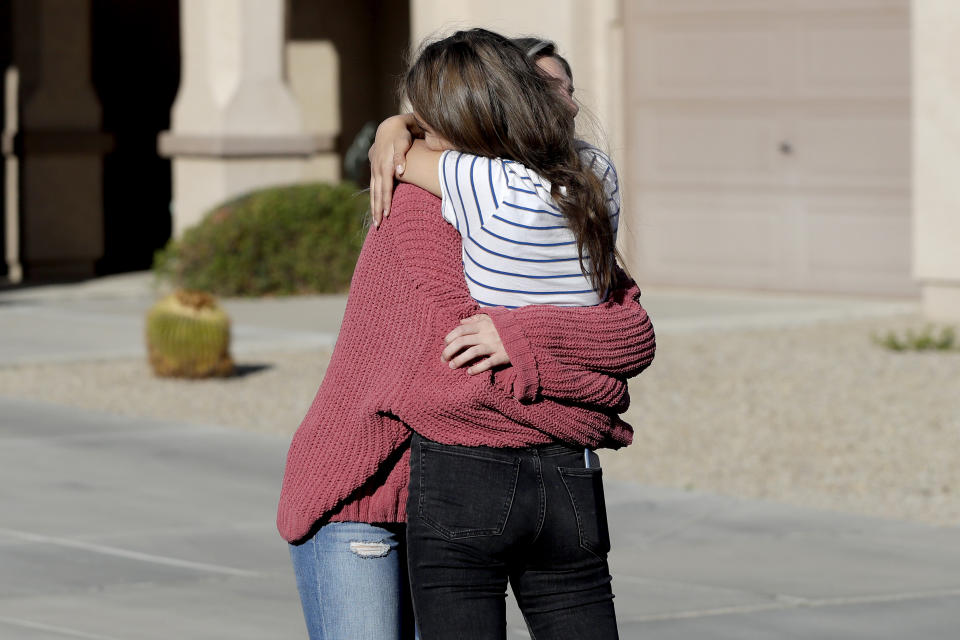 Madelyn Staddon, right, a relative of some of the members of a Mormon community who were attacked while traveling near the US-Mexico border, embraces a neighbor outside her home, Tuesday, Nov. 5, 2019, in Queen Creek, Ariz. Drug cartel gunmen ambushed three vehicles along a road near the state border of Chihuahua and Sonora on Monday, slaughtering at least six children and three women from the extended LeBaron family, all of them U.S. citizens living in northern Mexico, authorities said Tuesday. (AP Photo/Matt York)