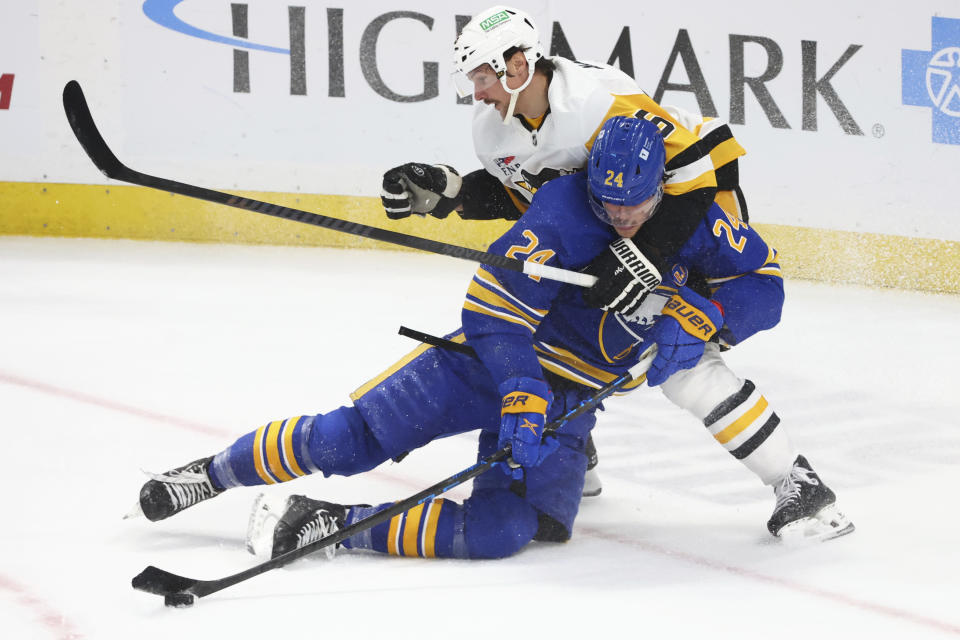 Buffalo Sabres center Dylan Cozens (24) is brought down by Pittsburgh Penguins defenseman Erik Karlsson (65) during the third period of an NHL hockey game Friday, Nov. 24, 2023, in Buffalo N.Y. (AP Photo/Jeffrey T. Barnes)